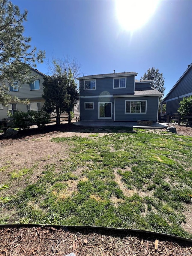 rear view of house featuring a patio area and a yard