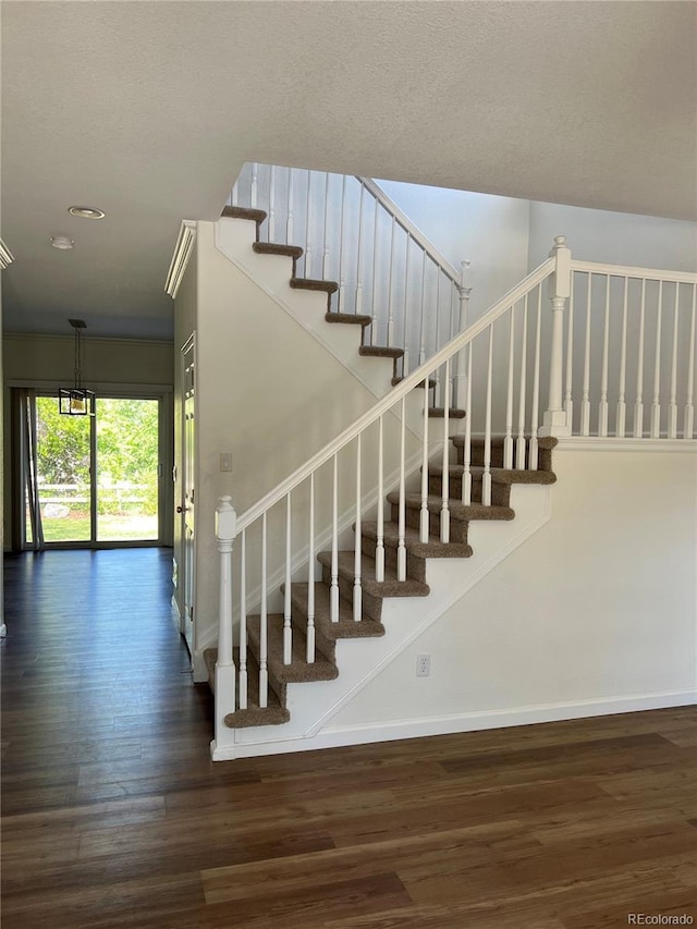 stairway featuring wood-type flooring and a textured ceiling