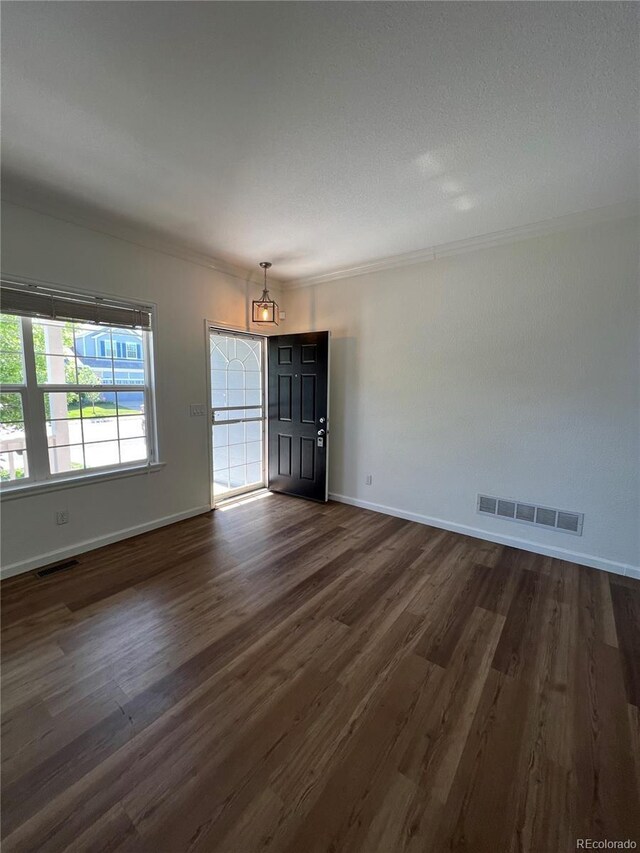 spare room with dark hardwood / wood-style flooring and ornamental molding