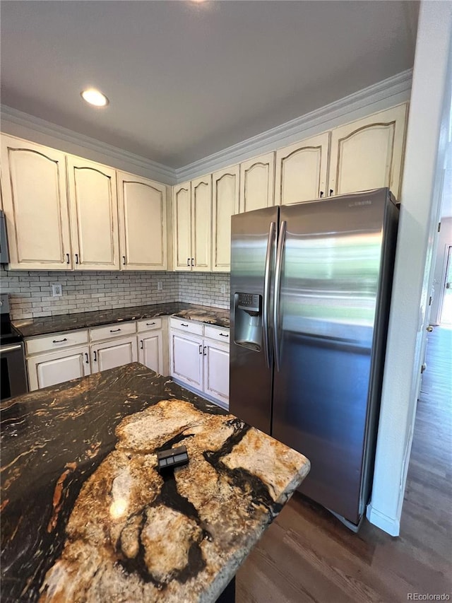 kitchen with stainless steel refrigerator with ice dispenser, crown molding, dark wood-type flooring, and dark stone countertops