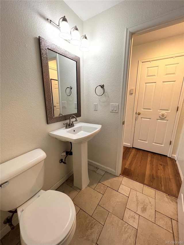 bathroom featuring sink, wood-type flooring, and toilet