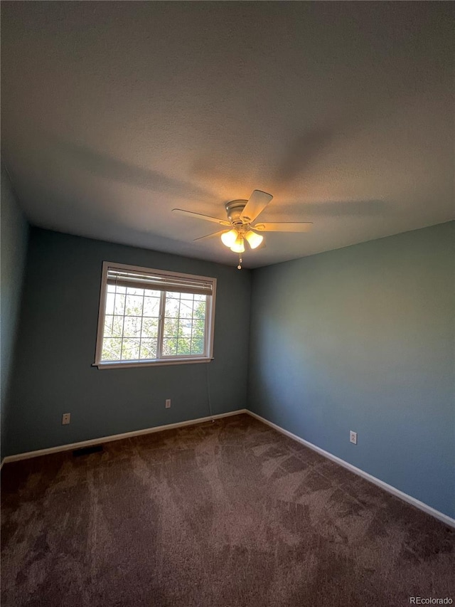 carpeted empty room with ceiling fan and a textured ceiling