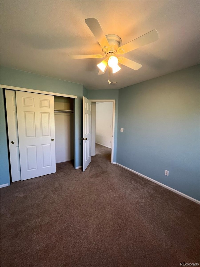 unfurnished bedroom with ceiling fan, a closet, and dark carpet