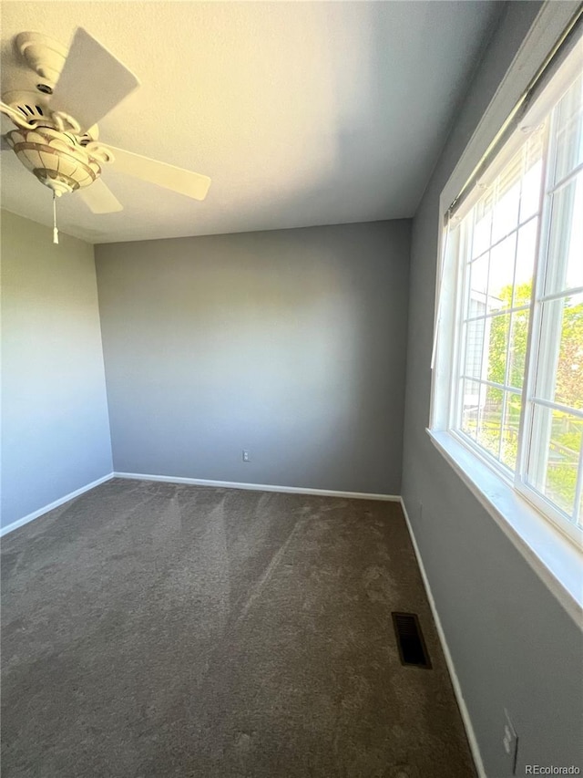 carpeted spare room featuring ceiling fan