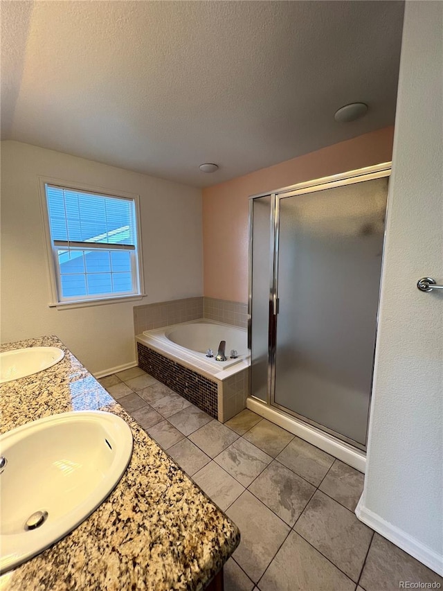 bathroom featuring tile patterned floors, vanity, a textured ceiling, and plus walk in shower