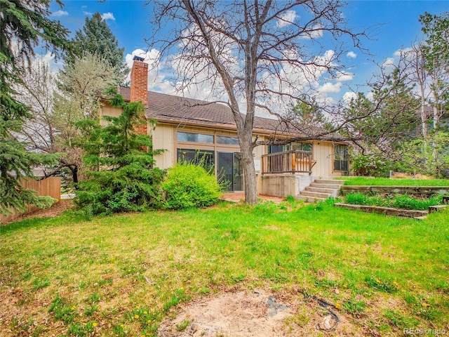 back of property featuring a yard and a chimney