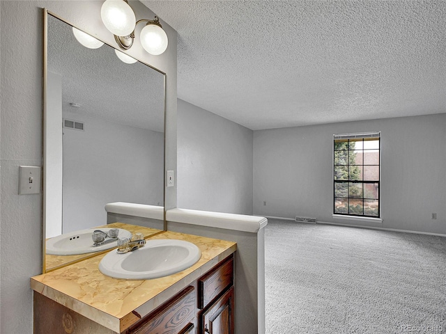 bathroom with visible vents, a textured ceiling, and vanity