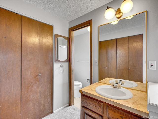 bathroom with toilet, a textured ceiling, and vanity