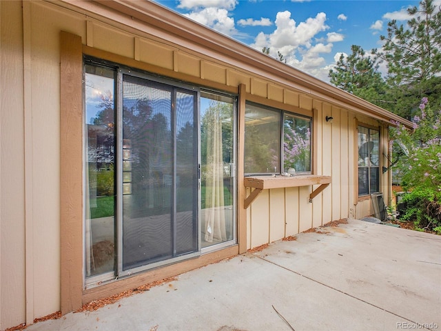 exterior space featuring board and batten siding and a patio area