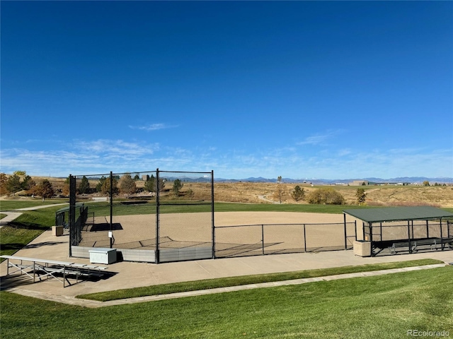 view of community with a lawn, a mountain view, and fence