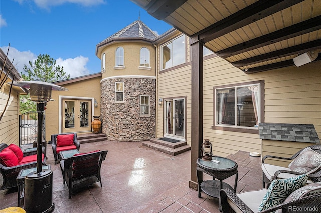 view of patio featuring an outdoor living space, french doors, entry steps, and a gate