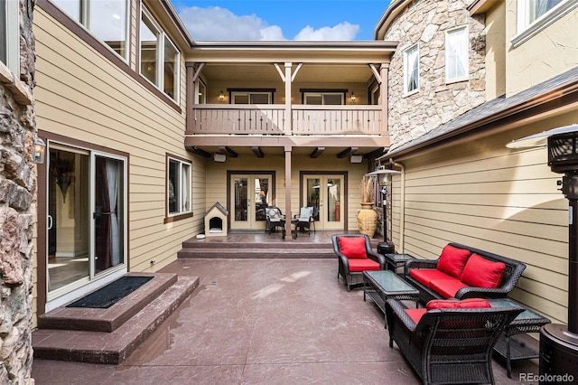 view of patio featuring an outdoor living space, a balcony, and french doors