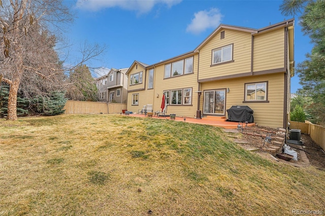 rear view of house with a yard, cooling unit, a fenced backyard, and a patio area