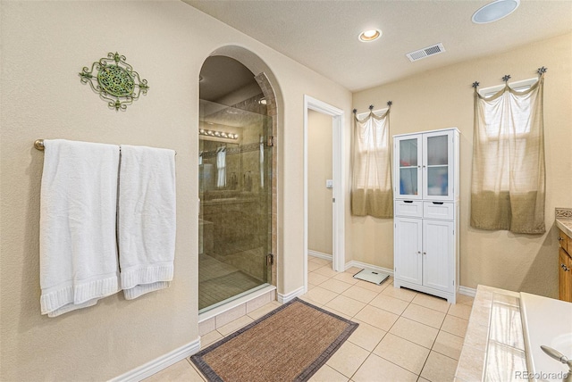 bathroom featuring vanity, visible vents, tile patterned flooring, and a stall shower