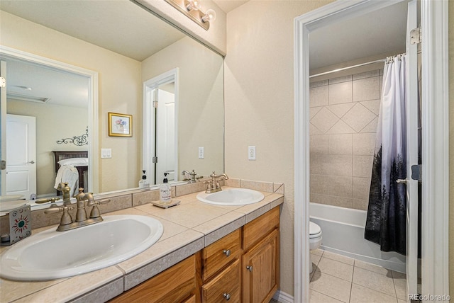 full bathroom featuring a sink, toilet, double vanity, and tile patterned floors