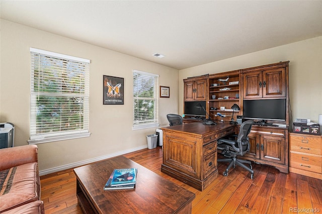 office featuring visible vents, baseboards, and dark wood finished floors