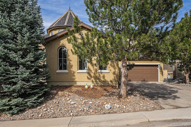 view of front facade with concrete driveway, an attached garage, and stucco siding