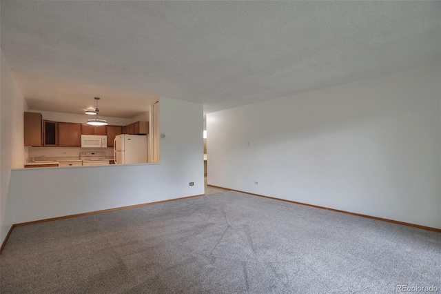 unfurnished living room featuring baseboards, a sink, and carpet floors