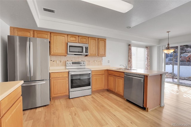 kitchen with tasteful backsplash, visible vents, light wood-type flooring, appliances with stainless steel finishes, and a peninsula