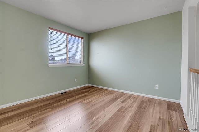 unfurnished room featuring visible vents, baseboards, and light wood-style floors