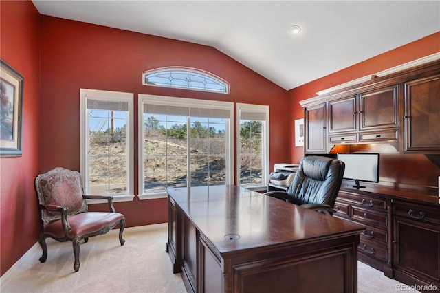 home office with vaulted ceiling, light carpet, and baseboards