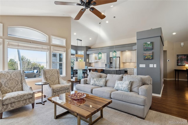 living area with recessed lighting, light wood-style flooring, ceiling fan, high vaulted ceiling, and baseboards