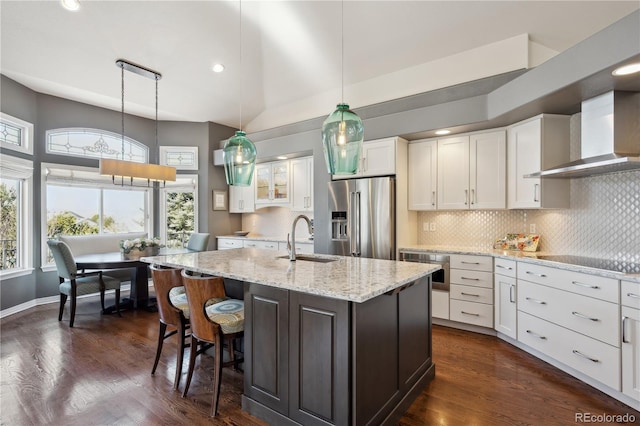 kitchen featuring wall chimney exhaust hood, appliances with stainless steel finishes, a sink, and white cabinets