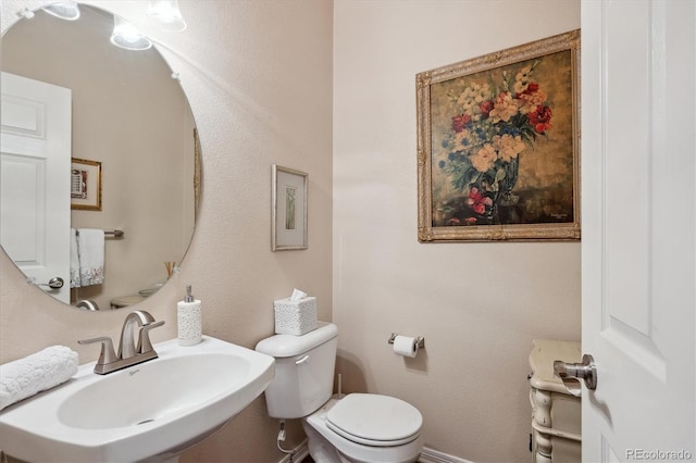 half bathroom featuring a sink and toilet