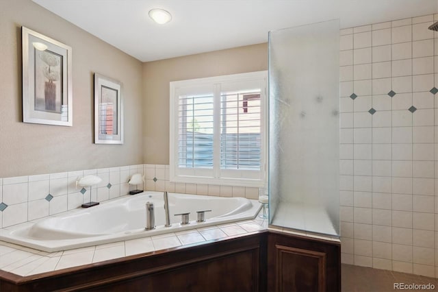 bathroom featuring a garden tub and walk in shower