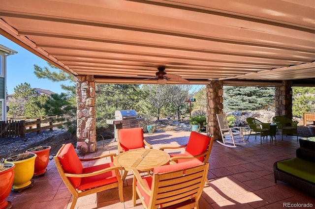 view of patio featuring outdoor dining area, fence, and a ceiling fan