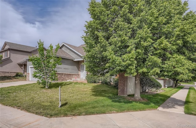 view of property exterior with an attached garage, brick siding, a yard, and concrete driveway