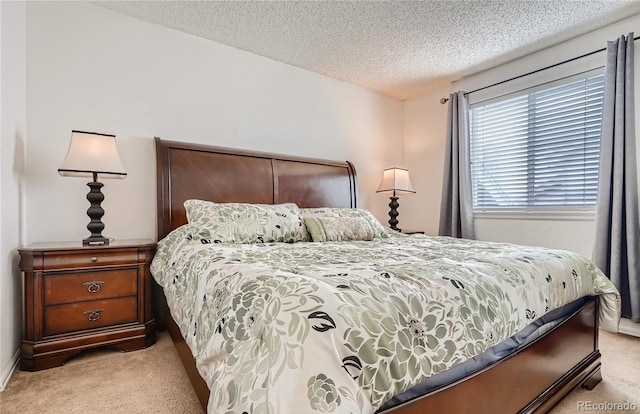bedroom featuring light carpet and a textured ceiling