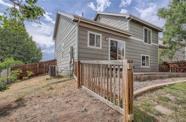rear view of property with fence and cooling unit
