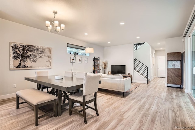 dining room with light hardwood / wood-style floors and an inviting chandelier