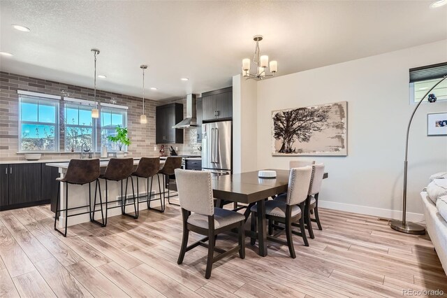 dining space with an inviting chandelier and light hardwood / wood-style flooring