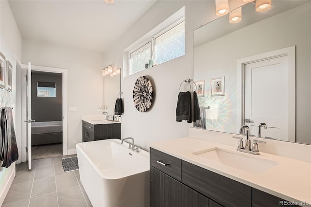 bathroom featuring tile patterned floors, vanity, and a tub to relax in