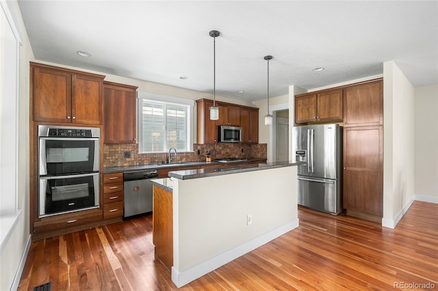 8029 E 23rd Ave, Denver, CO 80238 - kitchen with appliances with stainless steel finishes, dark wood-type flooring, a sink, backsplash, and dark countertops