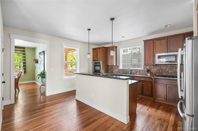 8029 E 23rd Ave, Denver, CO 80238 - kitchen with stainless steel appliances, a sink, dark wood-type flooring, backsplash, and plenty of natural light