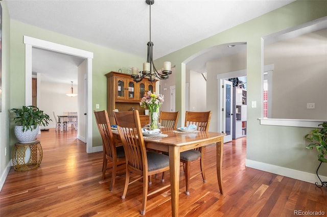 8029 E 23rd Ave, Denver, CO 80238 - dining space with wood finished floors, arched walkways, a chandelier, and baseboards