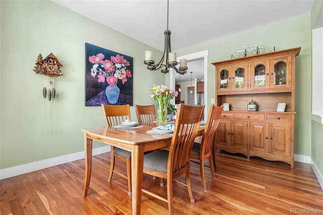 8029 E 23rd Ave, Denver, CO 80238 - dining space with a chandelier, light wood-style floors, and baseboards