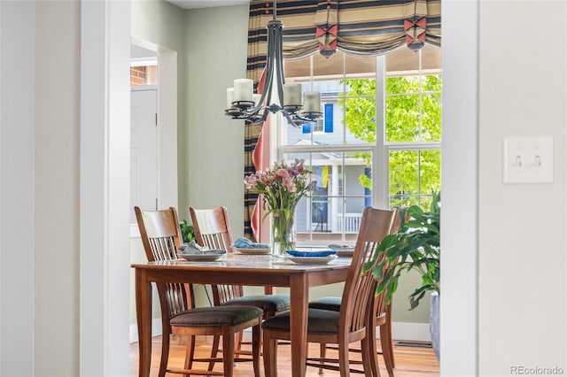 8029 E 23rd Ave, Denver, CO 80238 - dining room with a chandelier, wood finished floors, and baseboards
