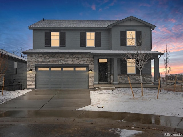 view of front facade featuring stone siding, a porch, driveway, and a garage