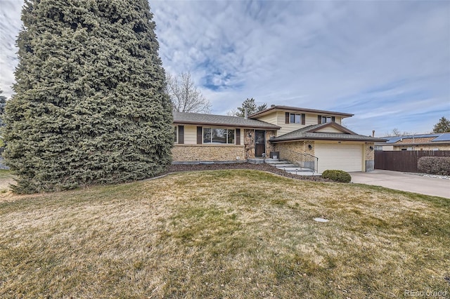 tri-level home featuring a garage and a front yard