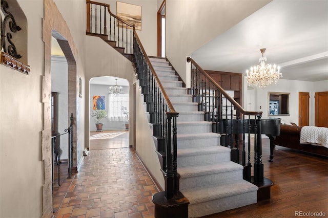 staircase featuring a notable chandelier and a towering ceiling