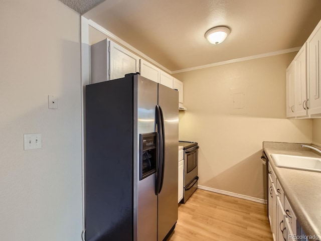 1200 Golden Cir Unit 412, Golden, CO 80401 - kitchen featuring appliances with stainless steel finishes, white cabinetry, light wood-style floors, crown molding, and light countertops