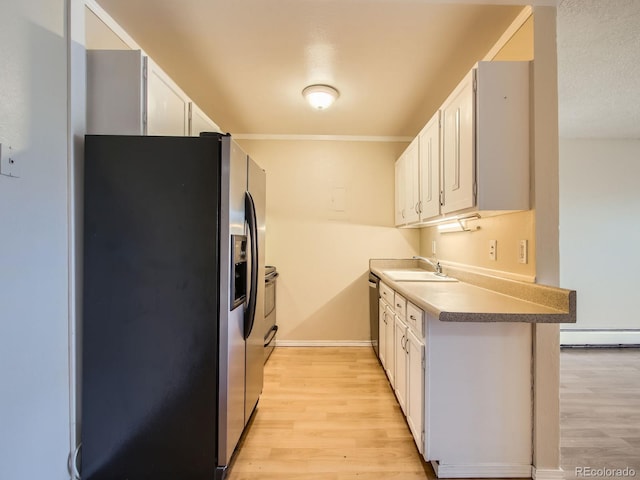 1200 Golden Cir Unit 412, Golden, CO 80401 - kitchen with stainless steel appliances, a baseboard heating unit, light wood-style floors, and white cabinetry