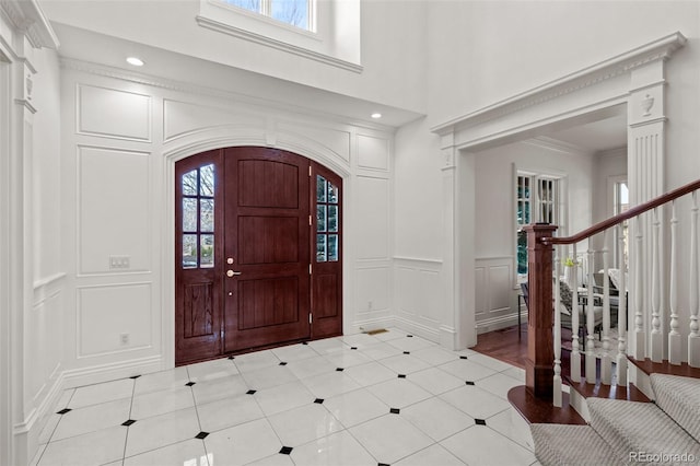 tiled foyer entrance with ornamental molding