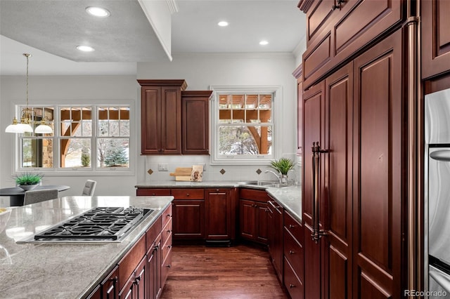 kitchen with a healthy amount of sunlight, stainless steel gas cooktop, sink, and light stone counters