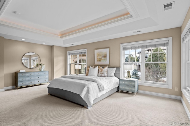 carpeted bedroom featuring ornamental molding and a tray ceiling