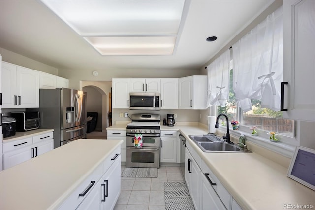 5552 S Lisbon Ln, Centennial, CO 80015 - kitchen with appliances with stainless steel finishes, white cabinetry, light tile patterned floors, light countertops, and arched walkways